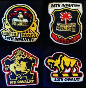 Four red yellow white and black patches on a navy blue background representing the 24th infantry, 25th infantry, 9th cavalry and 10th cavalry of the Buffalo Soldiers.