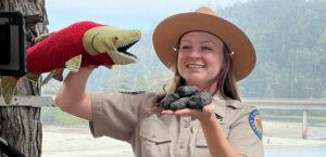 Program presenter holding salmon puppet