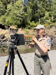Presenter displays a sample of juvenile fish to a camera.
